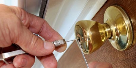 image of a locksmith picking a residential lock with professional tools